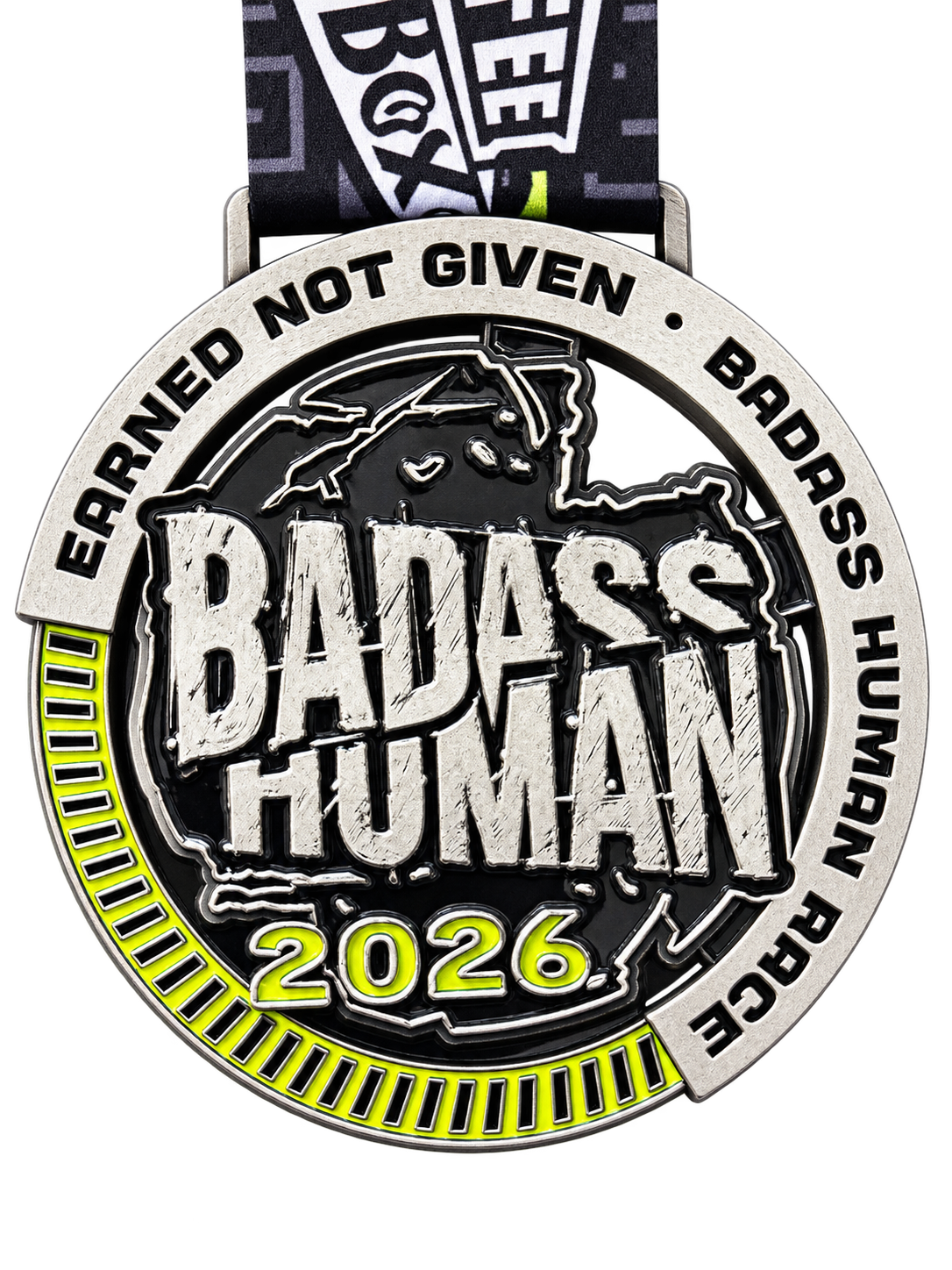 Actual 2026 Badass Human Race medal in silver, black and neon yellow-green, inscribed Earned Not Given